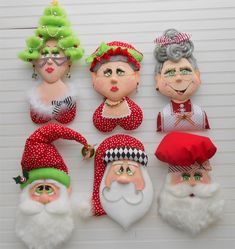 christmas ornaments are displayed on a wall in the shape of santa claus and other people