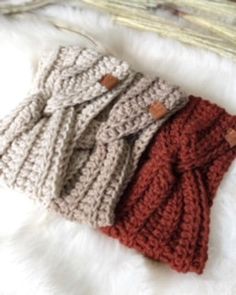 three knitted sweaters sitting on top of a white furnishing covered floor