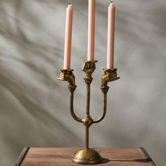 a brass candelabra with three candles on it