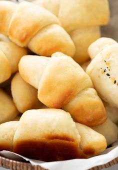 a basket filled with rolls covered in sesame seeds