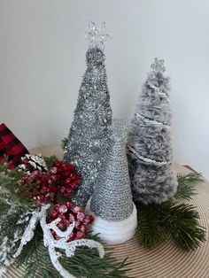 three small christmas trees sitting on top of a wooden table