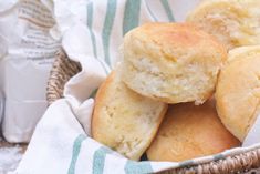 several rolls in a basket next to a bottle of milk