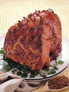 a piece of meat sitting on top of a white plate next to a wooden spoon