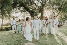 a bride and groom walking with their wedding party