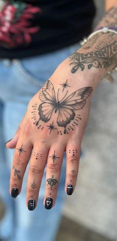 a woman's hand with tattoos on it and a butterfly tattooed on the palm