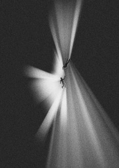 a person standing in the middle of a room with light coming from behind him and his shadow on the wall