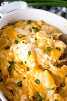 a white bowl filled with rice covered in cheese and green onions