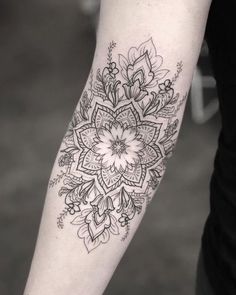 a black and white photo of a flower tattoo on the arm