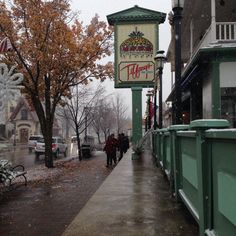 people walking down the sidewalk in front of a taco bell sign on a rainy day