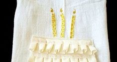 a white towel with gold sequins on it and two candles in the middle