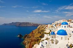 an aerial view of the blue and white buildings in oia