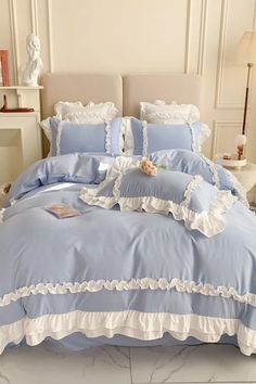 a blue and white bed with ruffled trimmings on the comforter is shown