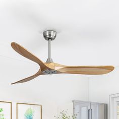 a modern ceiling fan with wooden blades in a living room or dining room area,