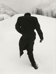 a man riding skis down the side of a snow covered slope