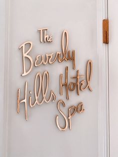 the beverly hills hotel spa sign is made out of copper letters on a white door