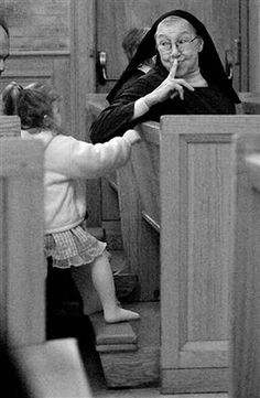 a woman and child are sitting in pews with their hands on each other's mouths