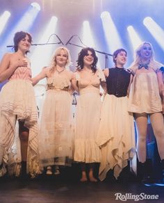 a group of women standing on top of a stage