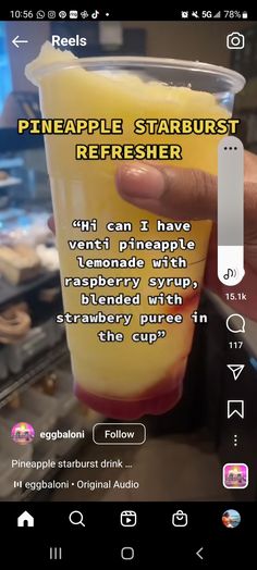 someone is holding up a cup with pineapple starburst refresher