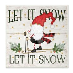 a wooden sign that says let it snow with a santa claus on skis and stars