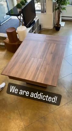 a wooden table sitting on top of a hard wood floor next to a tv monitor