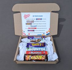 an open box filled with lots of different types of candy and snacks on top of a table