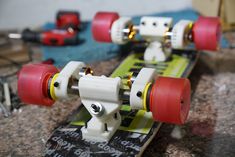 two skateboards with red and yellow wheels sitting on top of a table