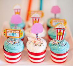 cupcakes with colorful frosting and sprinkles are on a tray