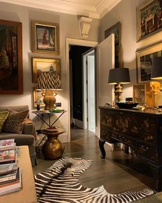 a living room filled with furniture and pictures on the wall above it's doorway