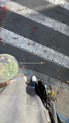 a person sitting on the ground with their skateboard in front of him and an empty plastic plate next to them