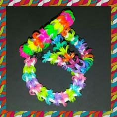 several different colored bracelets on top of a black surface with a square frame in the middle