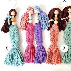 four different colors of yarn with wooden beads on each bead, and one in the shape of a mermaid