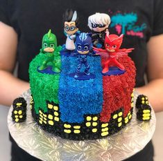 a birthday cake decorated to look like the characters from pj's is being held by someone