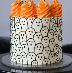 a decorated cake with orange frosting and sprinkles on it's sides