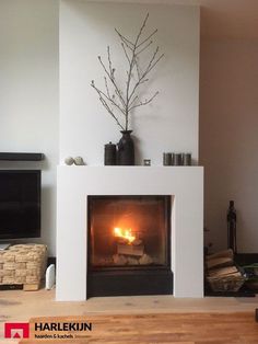 a living room with a fire place in the center and a television on the wall