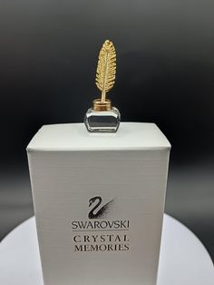 a white box with a gold trophy on top of it that says swaroski crystal memories