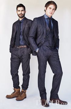 two men in suits standing next to each other with their hands on their hipss