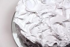 a close up of a cake on a plate with white frosting and icing