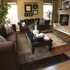 a living room with couches, tables and pictures on the wall in it's corner