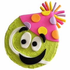 a green cake with a pink hat on top of it's head and eyes