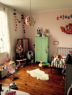 a child's bedroom with pink walls and wooden floors