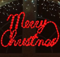 a lighted merry christmas sign on the side of a building