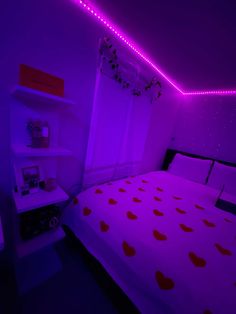 a bed with red hearts on it in a purple lit room that looks like a bedroom