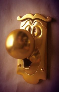 a golden door handle with a face on it