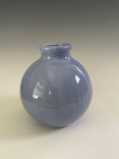 a blue vase sitting on top of a white table