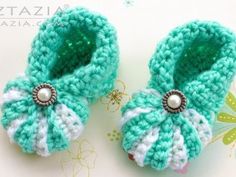 two crocheted baby shoes with pearls on them