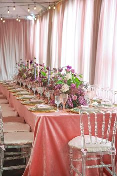 the table is set with pink linens and white chairs, along with floral centerpieces