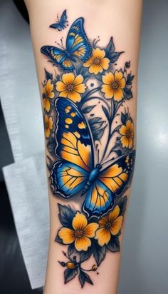 a woman's leg with yellow flowers and butterflies on it, while she is wearing a blue butterfly tattoo