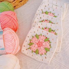 three balls of yarn sitting on top of a bed next to some crochet