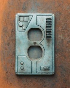 an electrical outlet cover on the side of a metal wall mounted device with two outlets