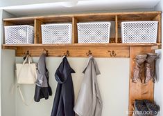 a coat rack with baskets and umbrellas hanging from it's hooks on the wall